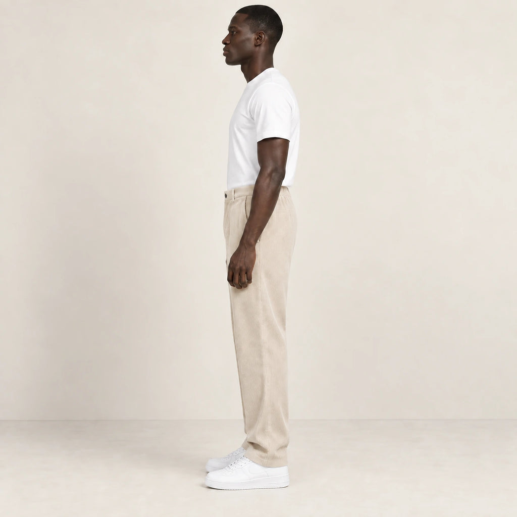 Pantalon beige en velours côtelé à fine rayure, profil dans le studio IVAREE