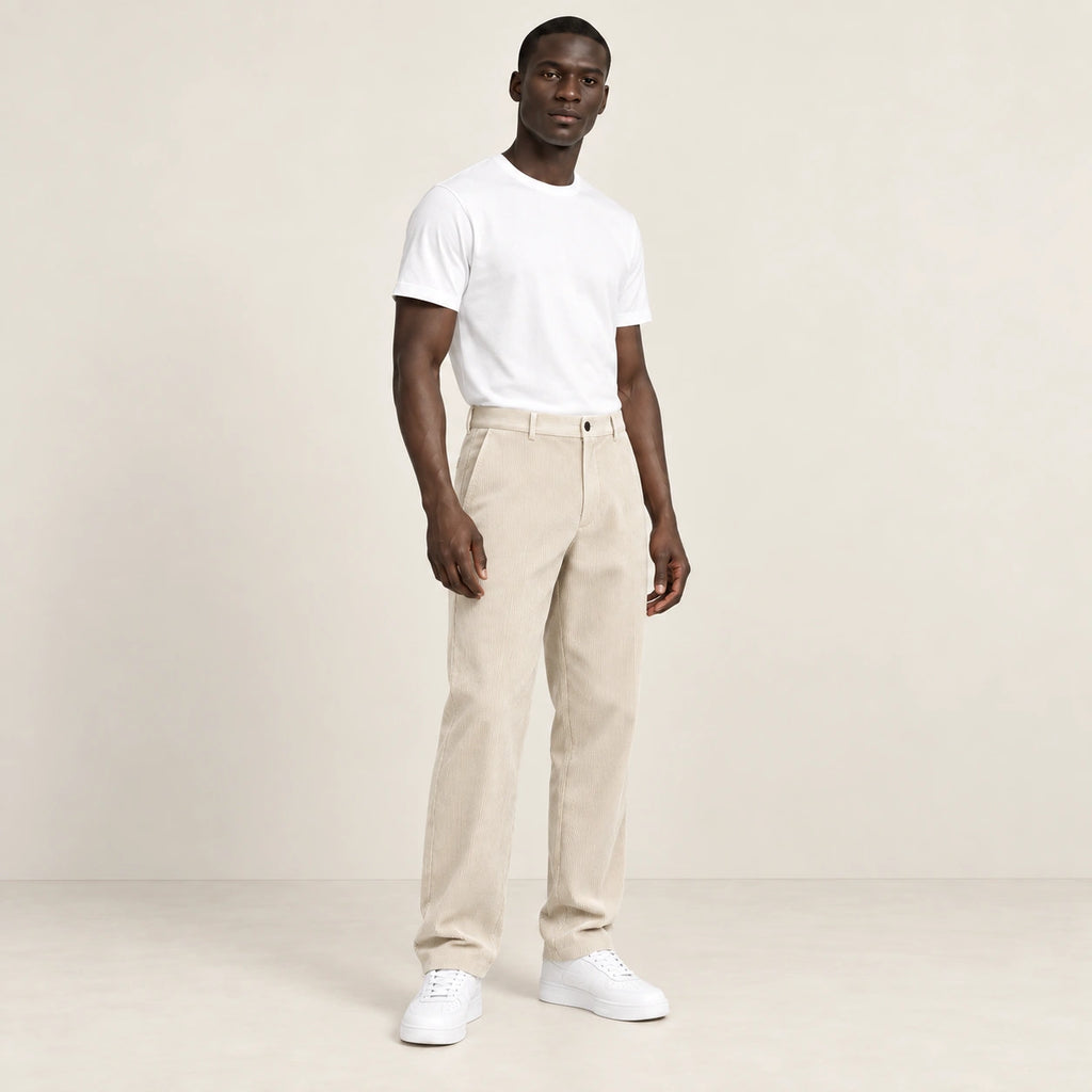 Pantalon beige en velours côtelé à fine rayure, trois-quarts dans le studio IVAREE