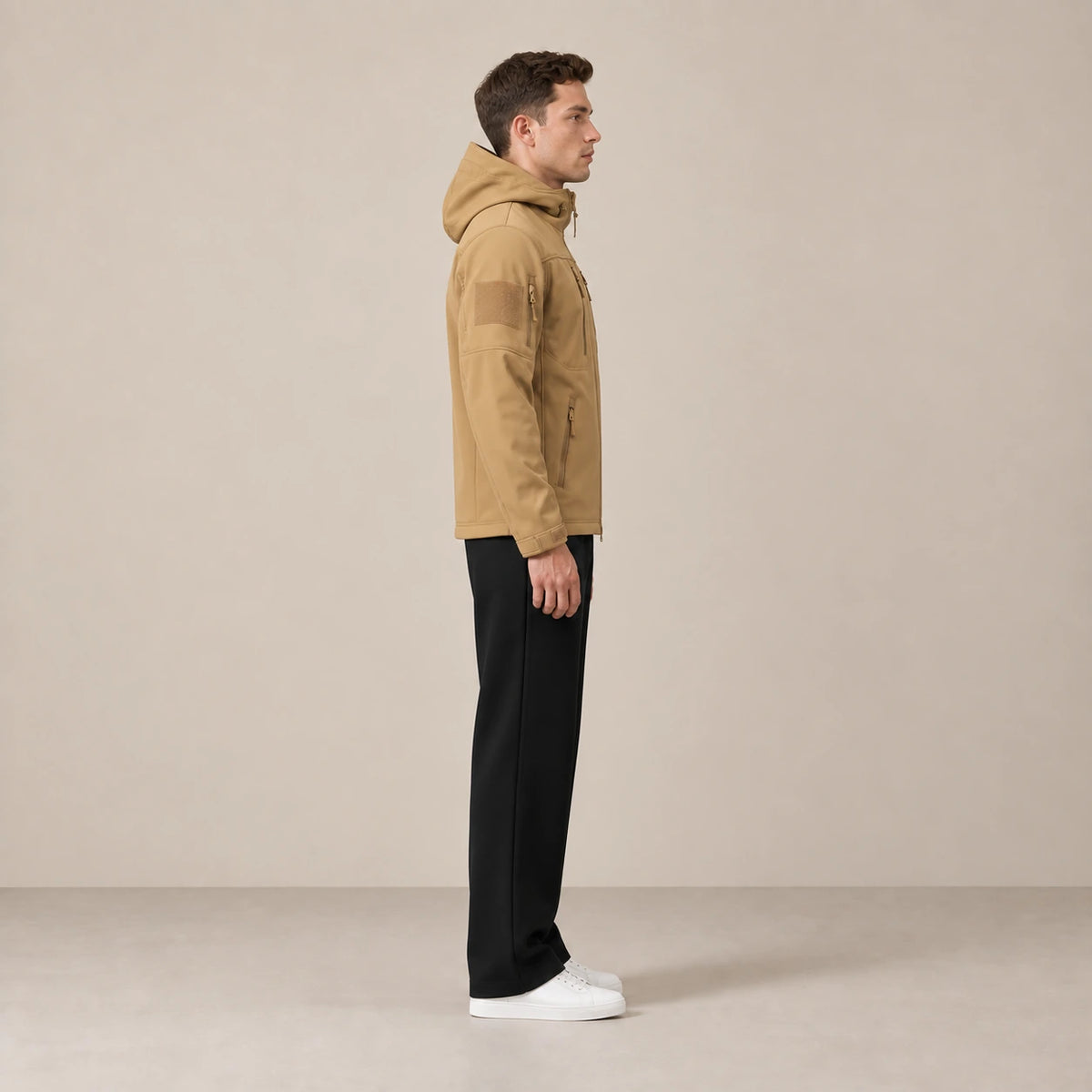 Parka à capuche doublée polaire multipoche camel, portée de profil dans le studio IVAREE.