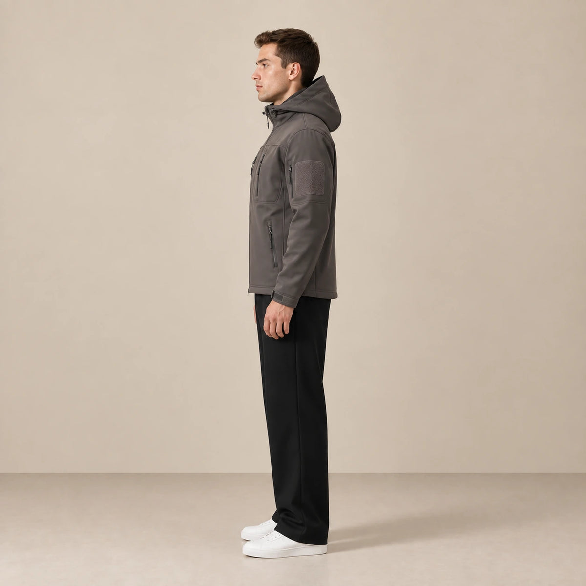 Parka à capuche doublée polaire multipoche gris foncé, portée de profil dans le studio IVAREE.