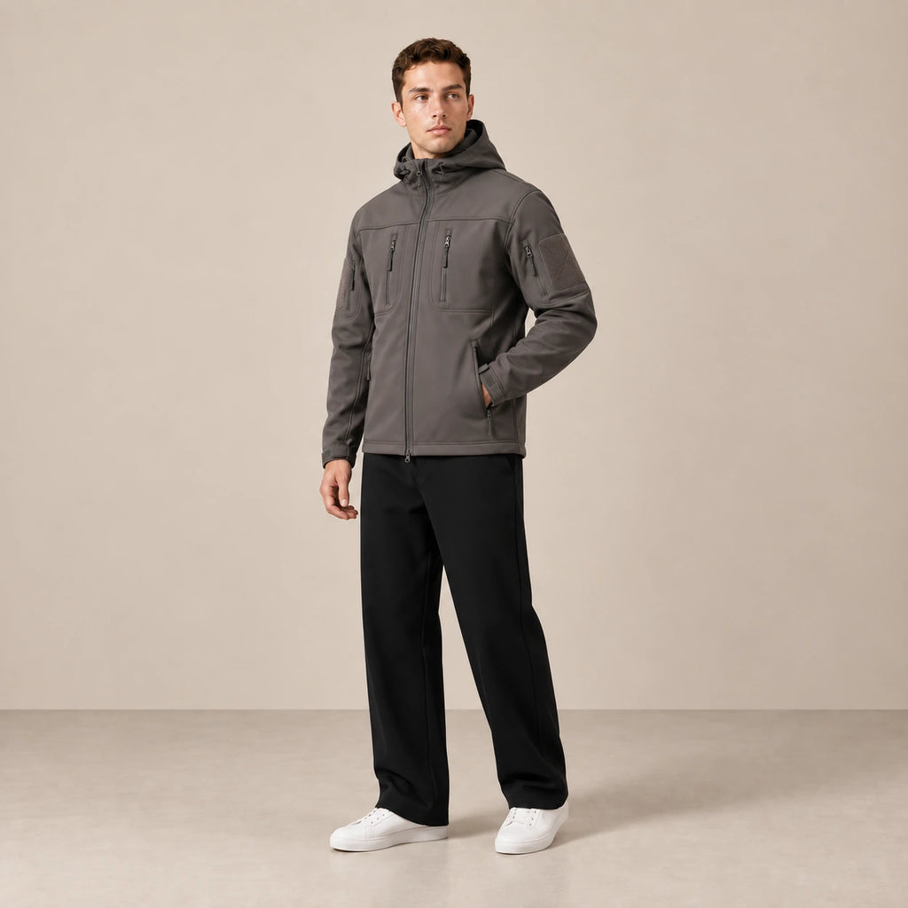 Parka à capuche doublée polaire multipoche gris foncé, portée de trois-quarts dans le studio IVAREE.