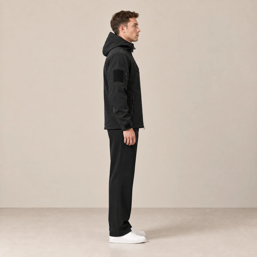 Parka à capuche doublée polaire multipoche noir, portée de profil dans le studio IVAREE.