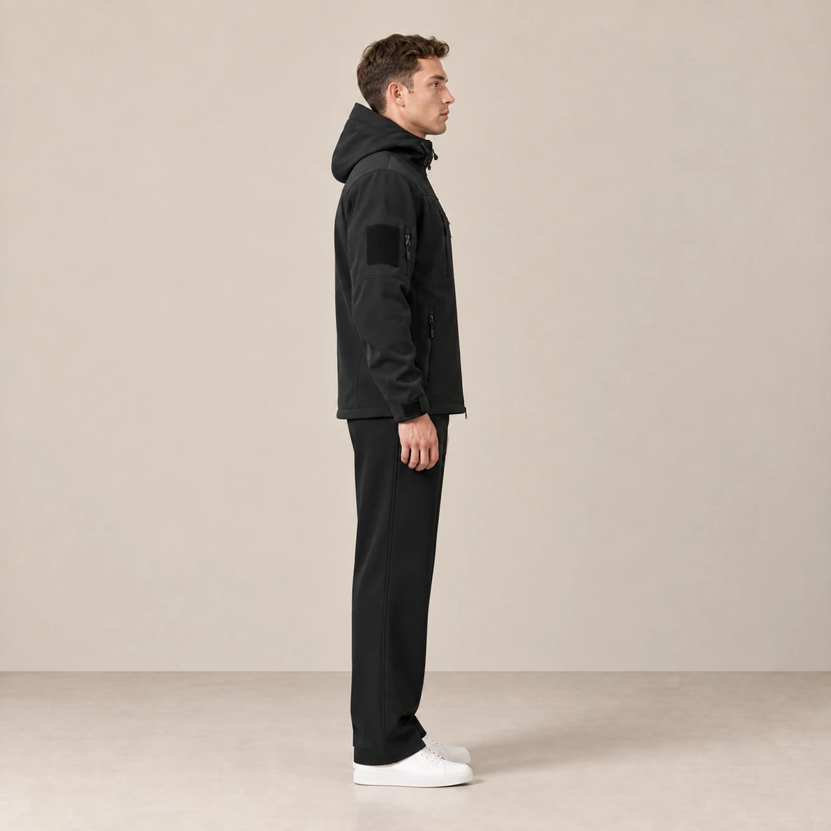 Parka à capuche doublée polaire multipoche noir, portée de profil dans le studio IVAREE.