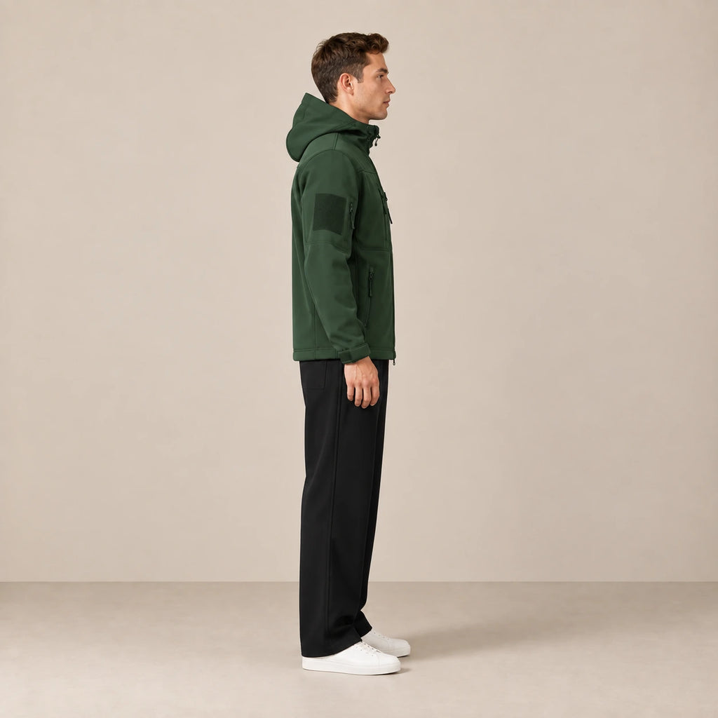 Parka à capuche doublée polaire multipoche vert foncé, portée de profil dans le studio IVAREE.