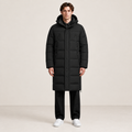 Parka longue noire matelassée à capuche et quatre poches zippées, vue de face dans le studio IVAREE, format carré 1:1.
