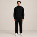 Pull homme noir à col montant et maille fine, porté de face en studio.