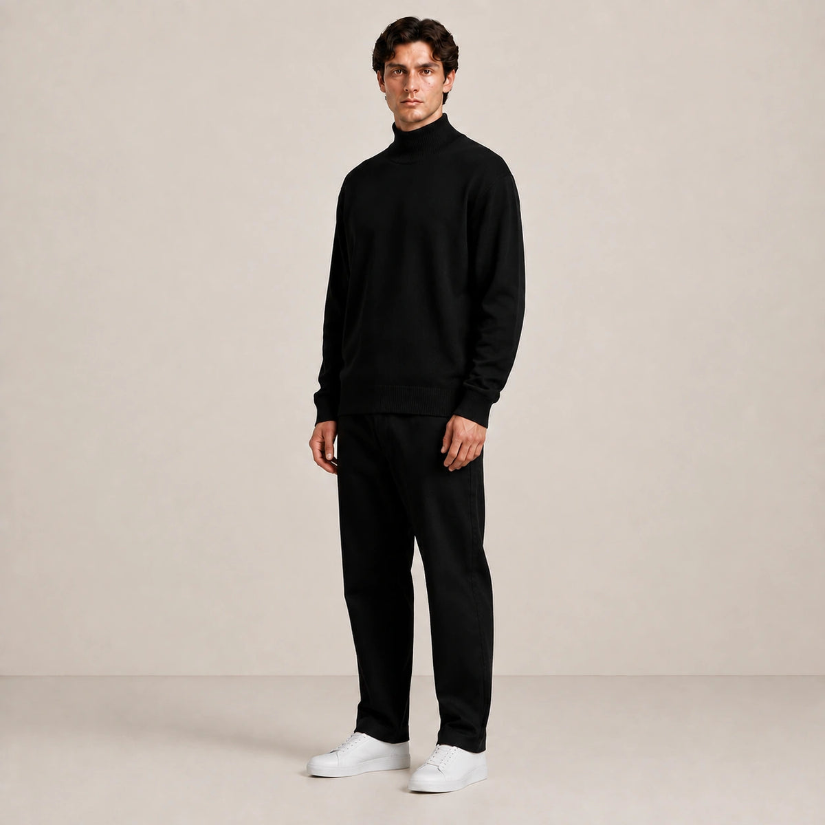 Pull homme noir à col montant, porté de trois quarts en studio.