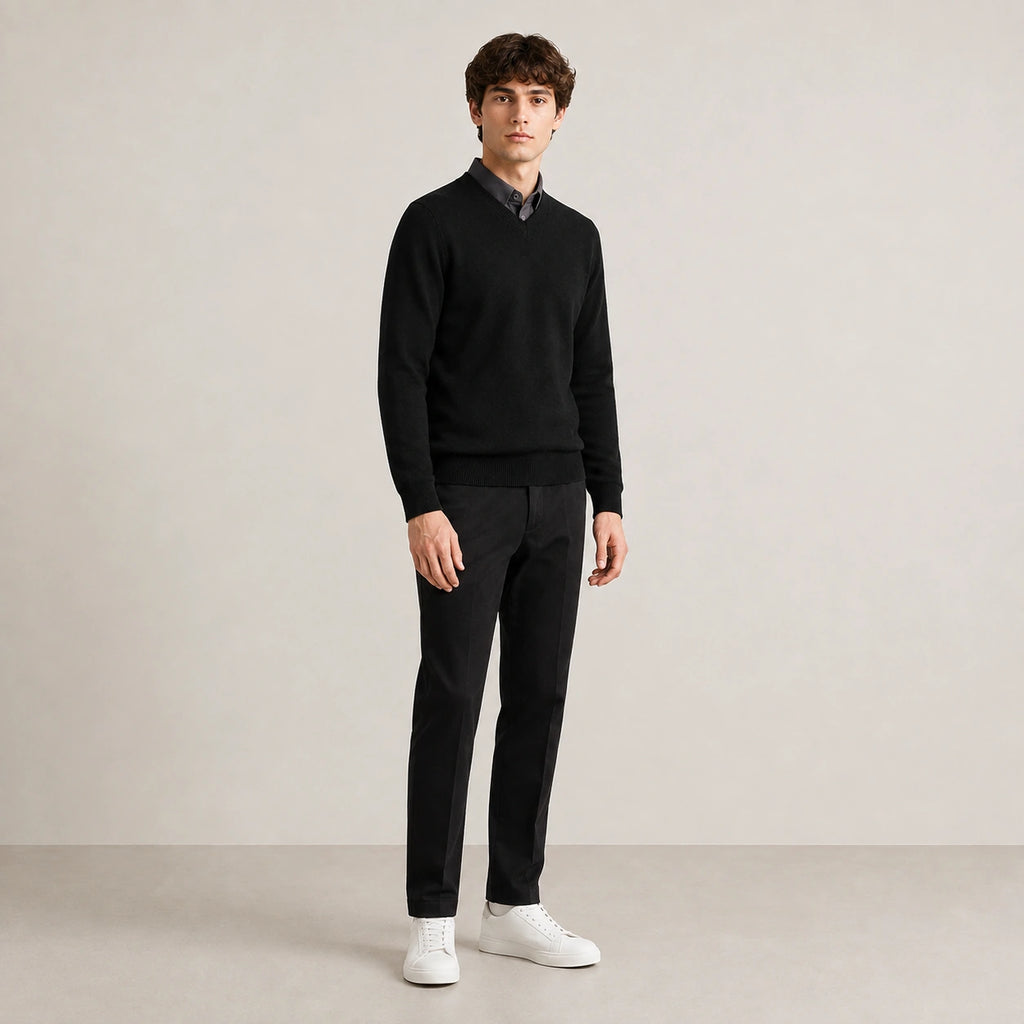 Pull col V noir en maille fine, porté de trois quarts dans le studio IVAREE.