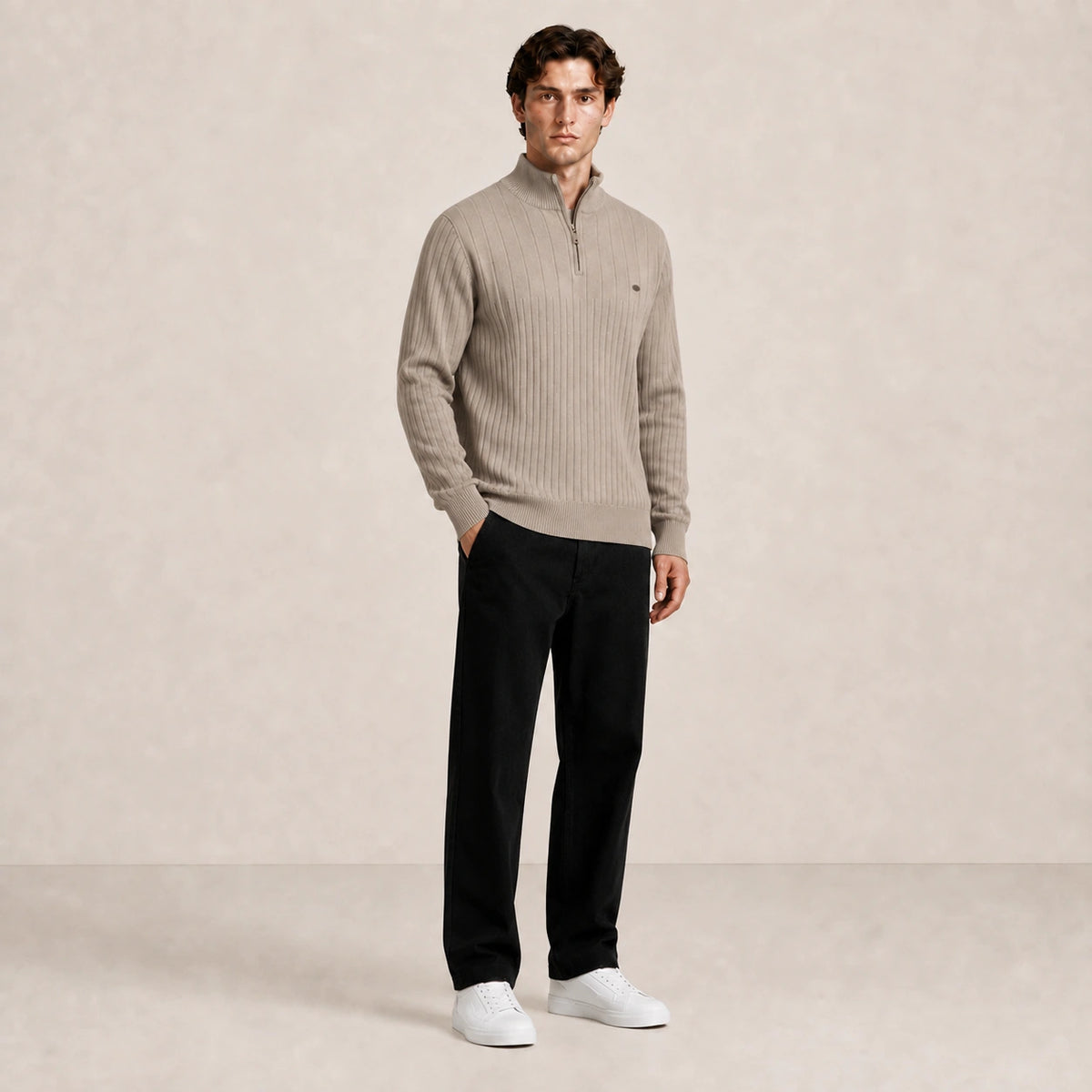 Pull homme beige taupe, porté de trois-quarts en pied dans le studio IVAREE.