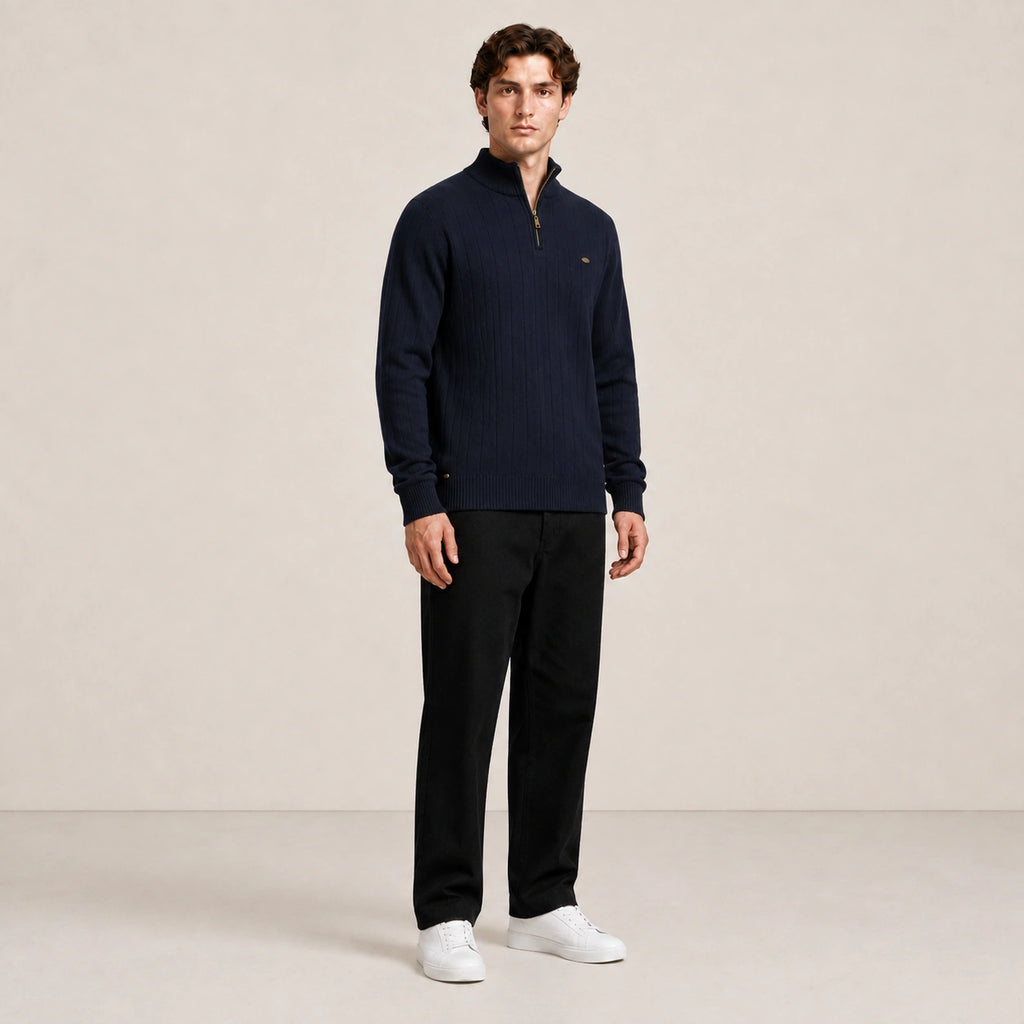 Pull homme à col zippé et côtes verticales bleu marine, porté de trois-quarts en studio IVAREE.