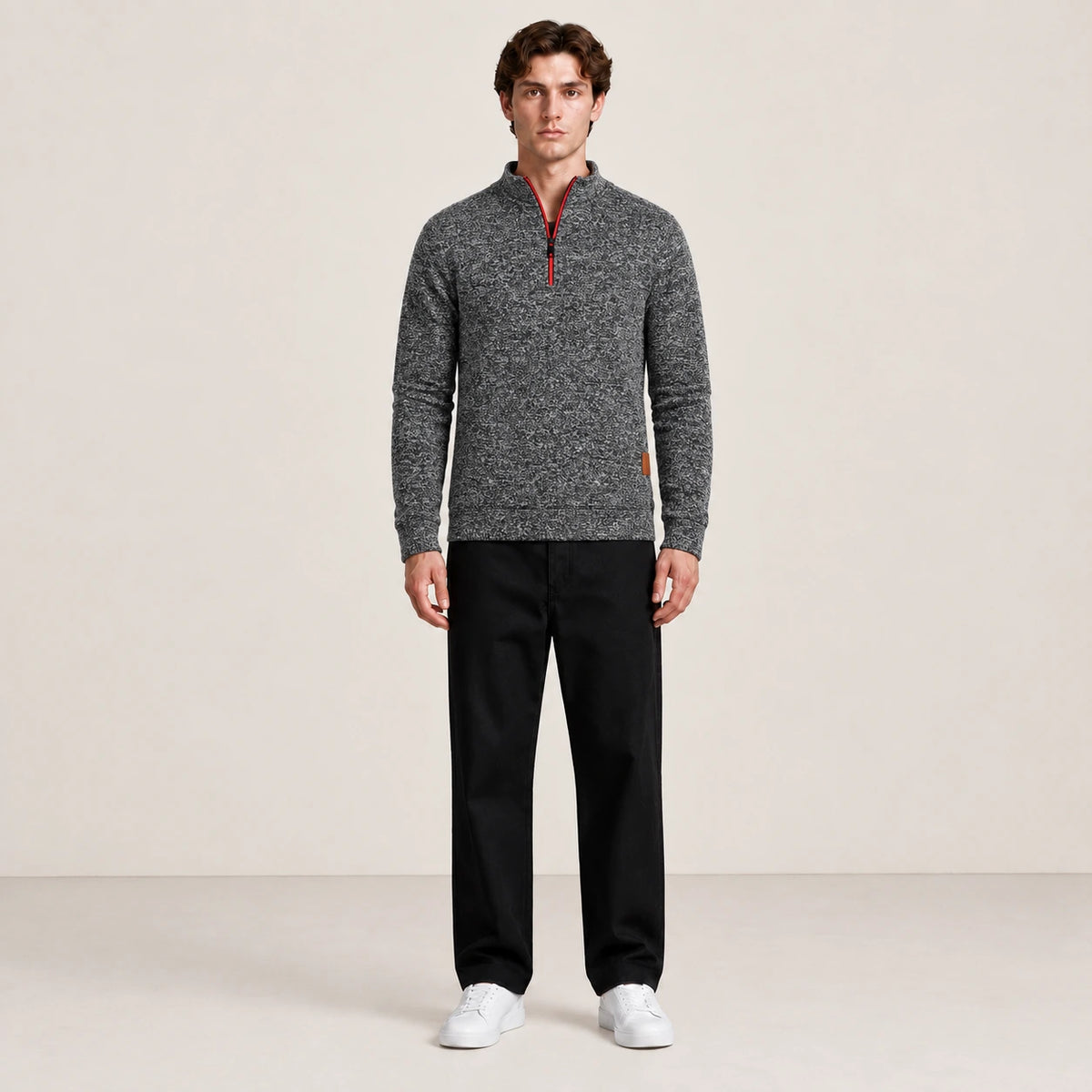 Pull à col zippé gris foncé chiné porté de face dans le studio IVAREE.