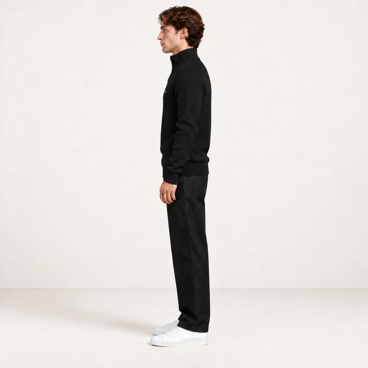 Pull demi-zip noir en maille côtelée, vue de profil dans le studio IVAREE
