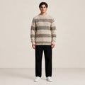 Pull homme en grosse maille beige à rayures, porté de face en studio IVAREE.
