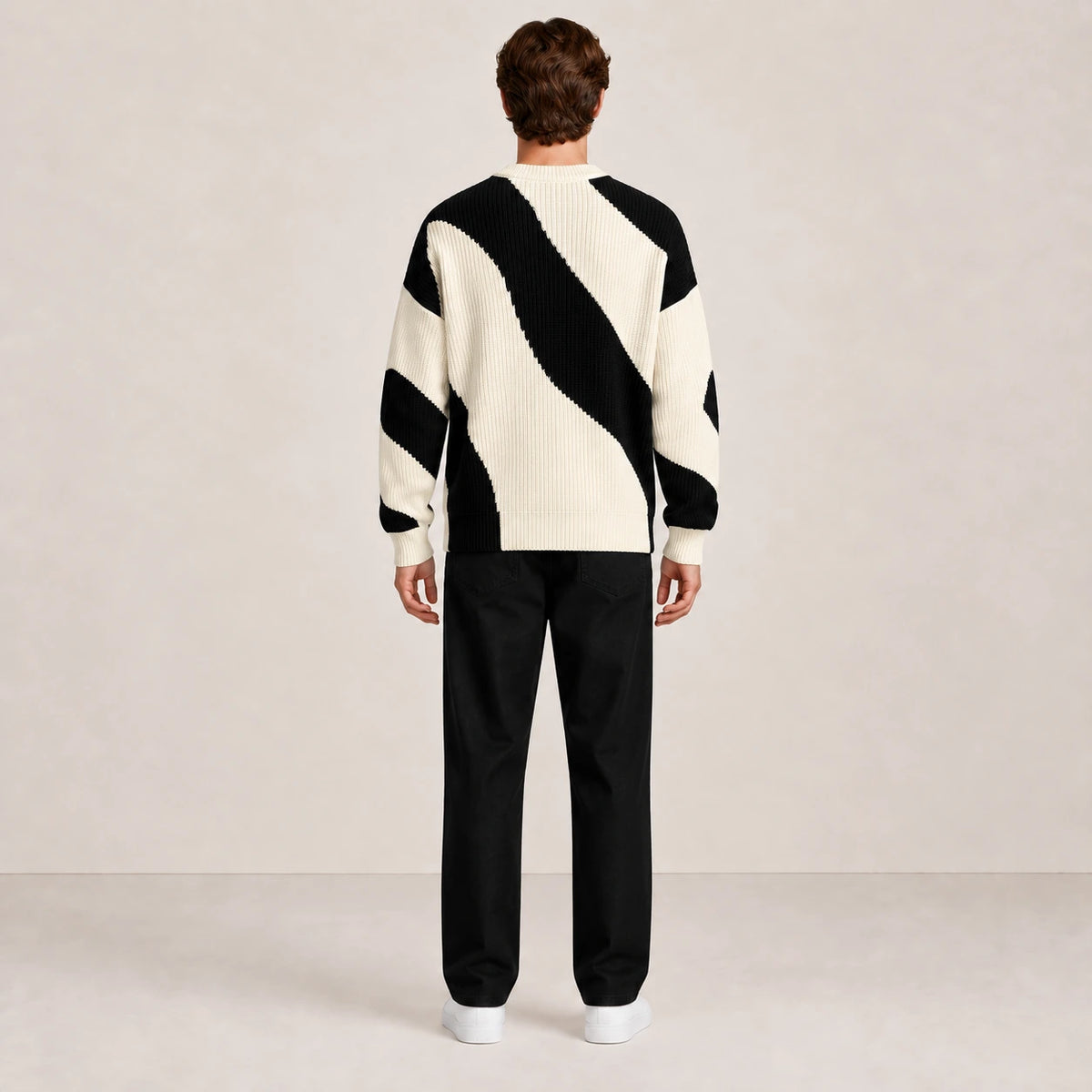 Pull en maille à motif ondulé noir et écru, vue de dos dans le studio IVAREE