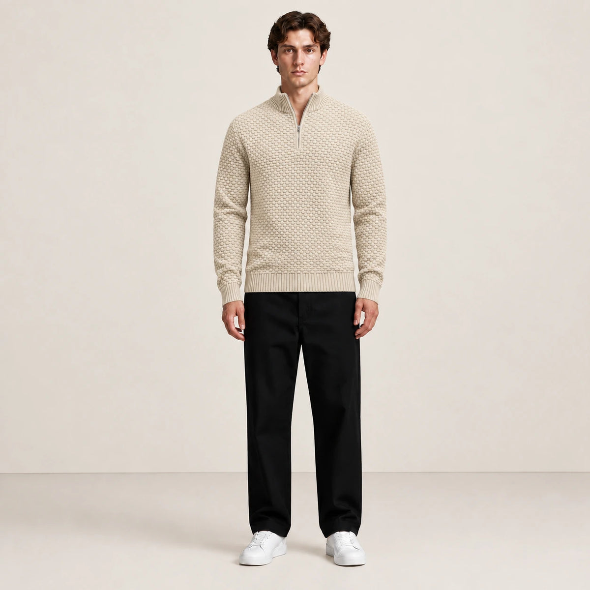 Pull beige en maille nid d'abeille à col zippé porté de face dans le studio IVAREE.