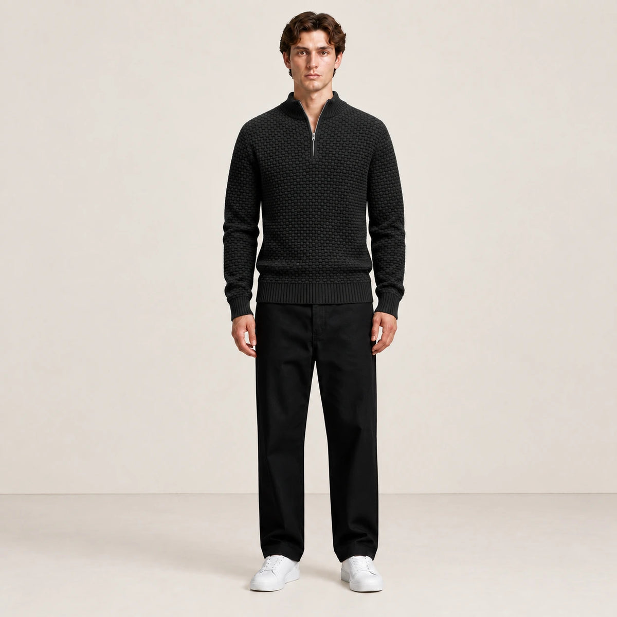 Pull noir en maille nid d'abeille à col zippé porté de face dans le studio IVAREE.