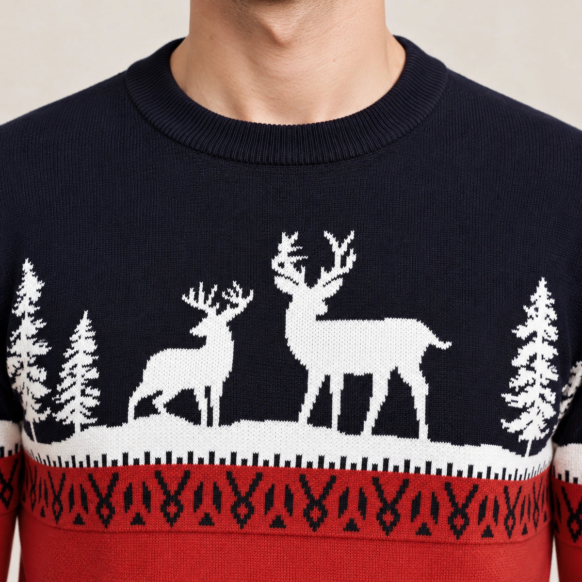 Pull rouge et bleu marine à motifs de rennes et sapins blancs, détail du col côtelé et des motifs tricotés, studio IVAREE.