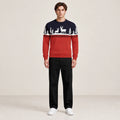 Pull rouge et bleu marine à motifs de rennes et sapins blancs, porté de face dans le studio IVAREE.