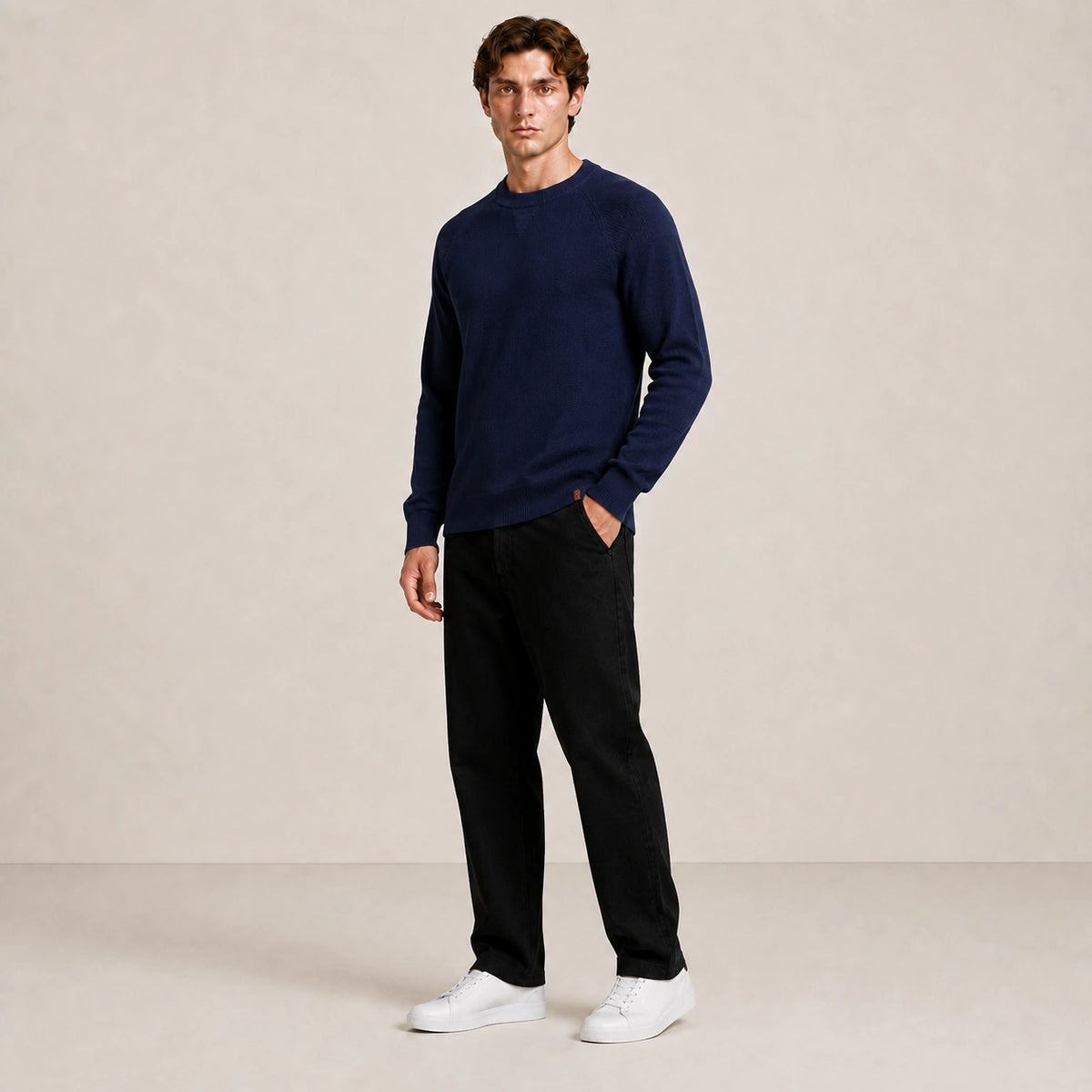 Pull homme bleu marine, porté de trois-quarts en pied dans le studio IVAREE.