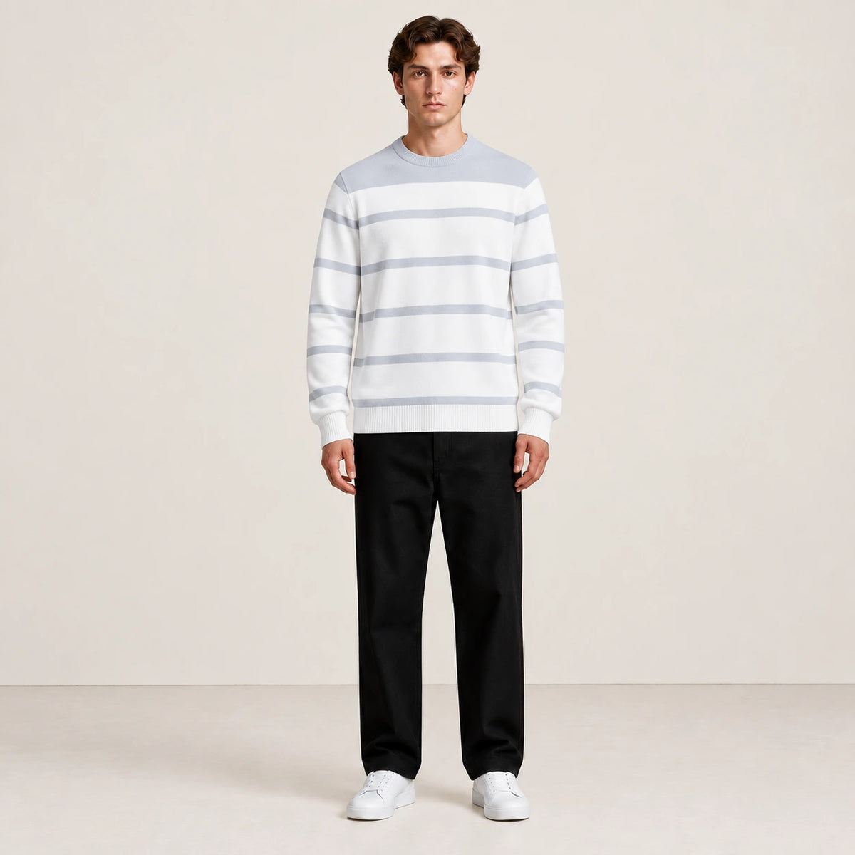 Pull rayé gris et blanc à col rond porté de face dans le studio IVAREE.