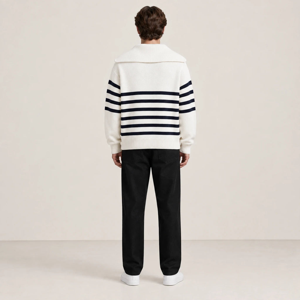 Pull rayé blanc et noir à col zippé porté de dos dans le studio IVAREE.