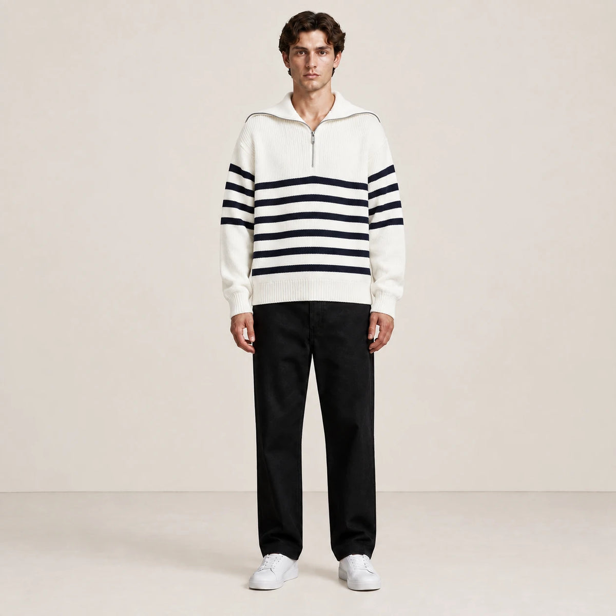 Pull rayé blanc et noir à col zippé porté de face dans le studio IVAREE.