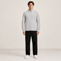 Pull zippé gris clair à col montant porté de face dans le studio IVAREE.