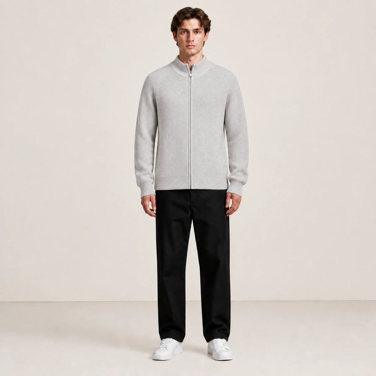 Pull zippé gris clair à col montant porté de face dans le studio IVAREE.