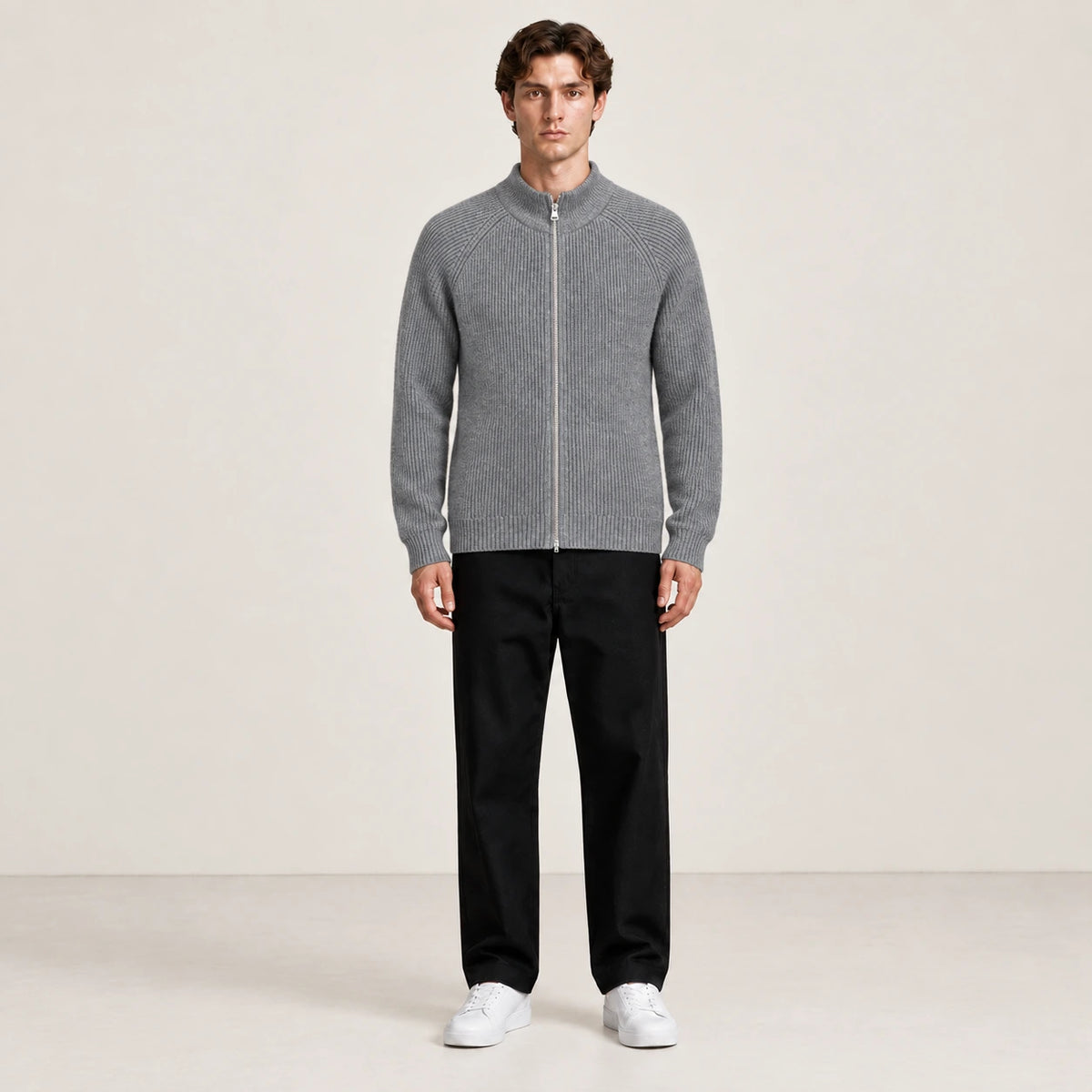 Pull zippé gris à col montant porté de face dans le studio IVAREE.