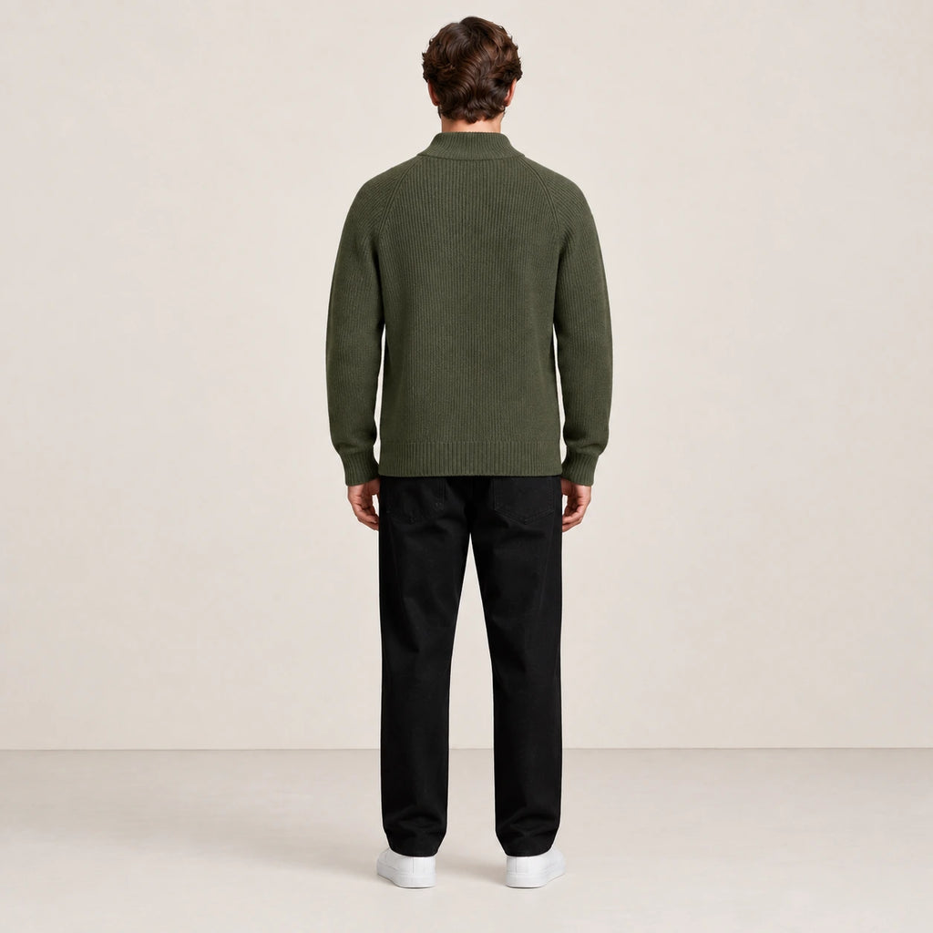 Pull zippé vert foncé à col montant porté de dos dans le studio IVAREE.