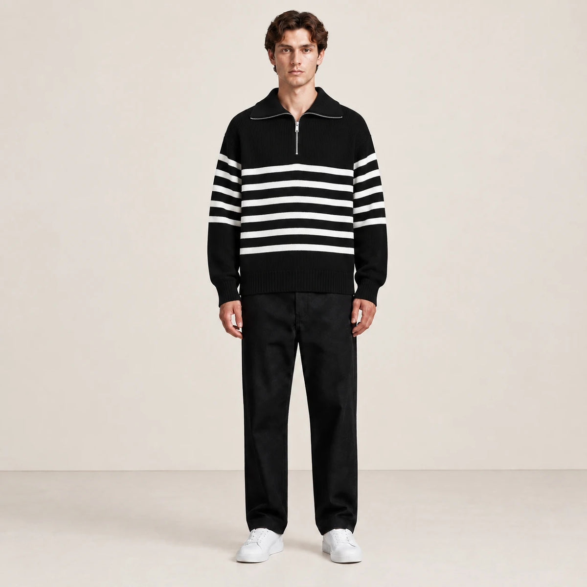 Pull rayé noir et blanc à col zippé porté de face dans le studio IVAREE.