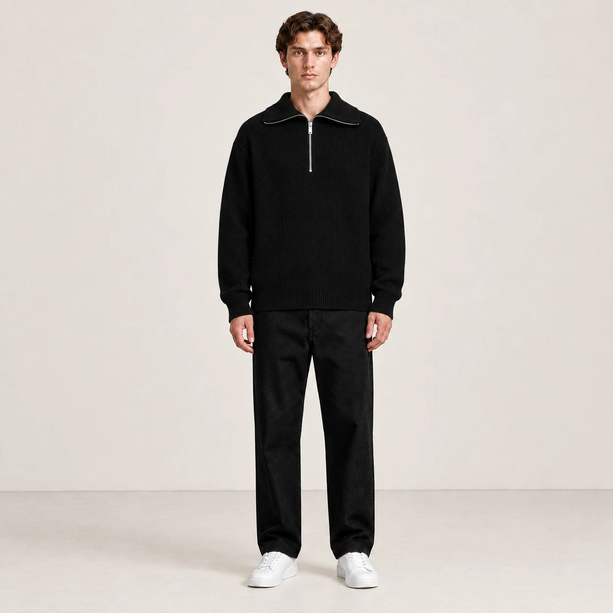 Pull noir à col zippé porté de face dans le studio IVAREE.