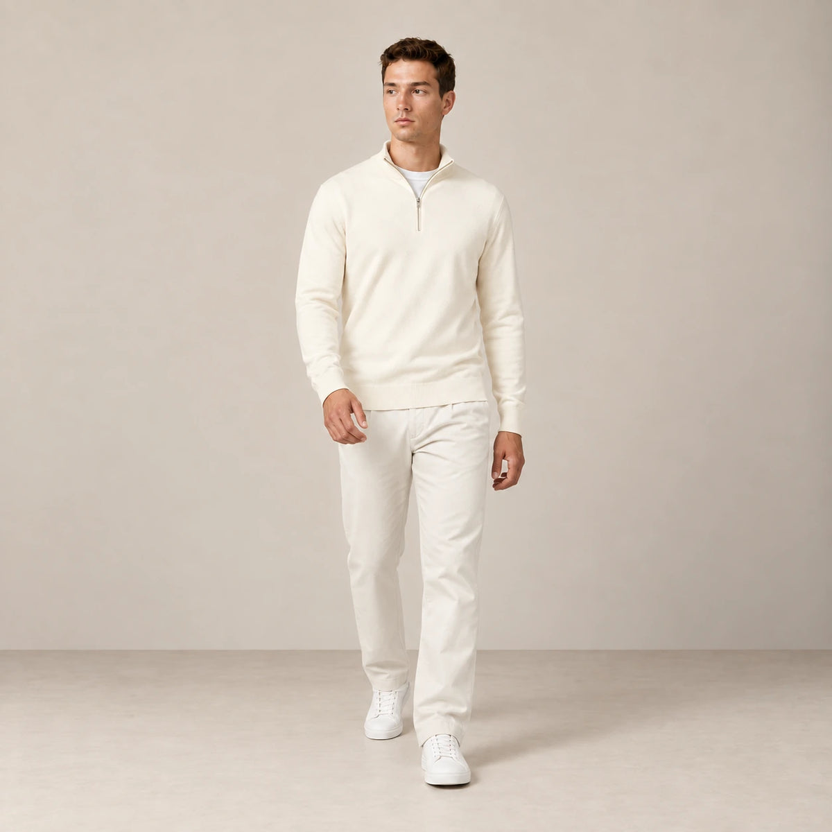 Sweat blanc cassé à demi-zip porté en marche dans le studio IVAREE.