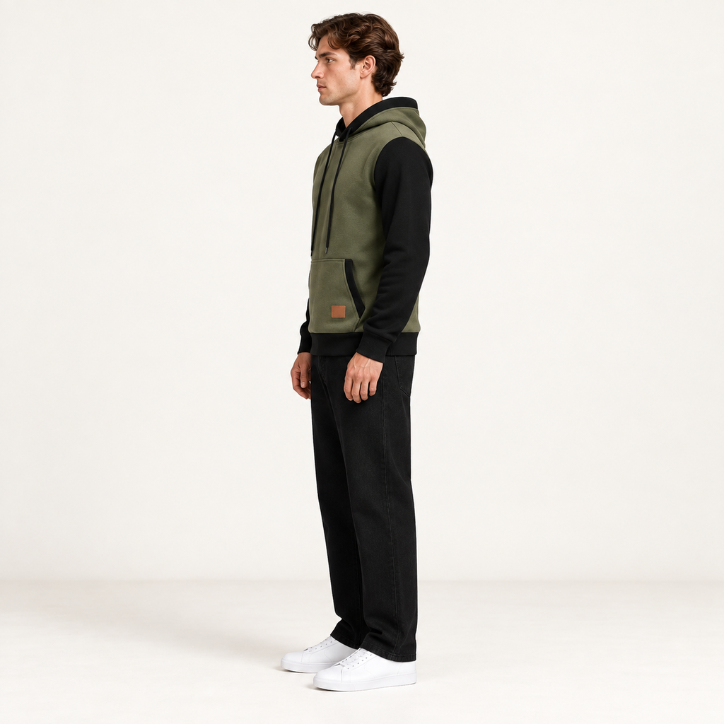 Sweat à capuche color-block vert et noir, vu de profil dans le studio IVAREE.