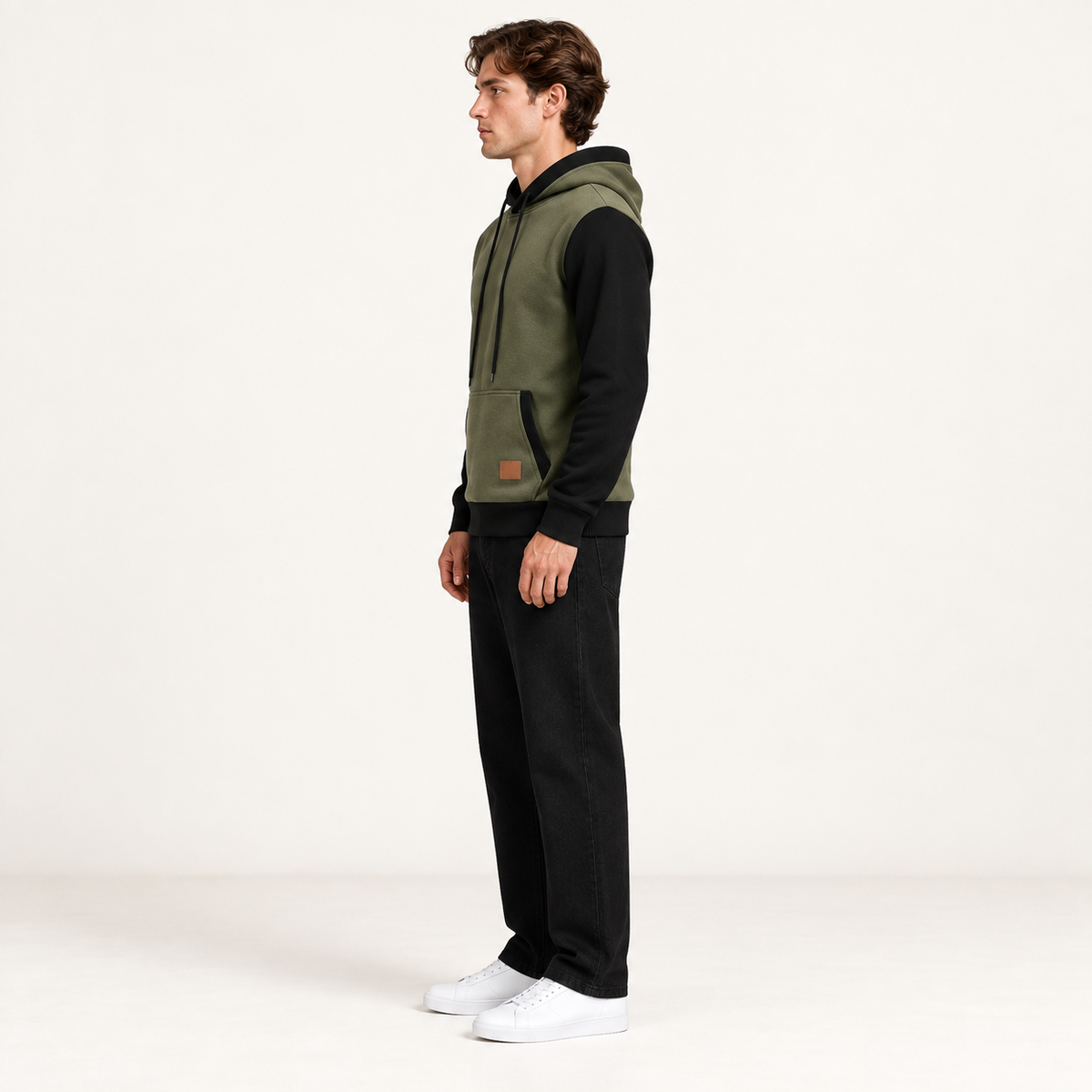 Sweat à capuche color-block vert et noir, vu de profil dans le studio IVAREE.