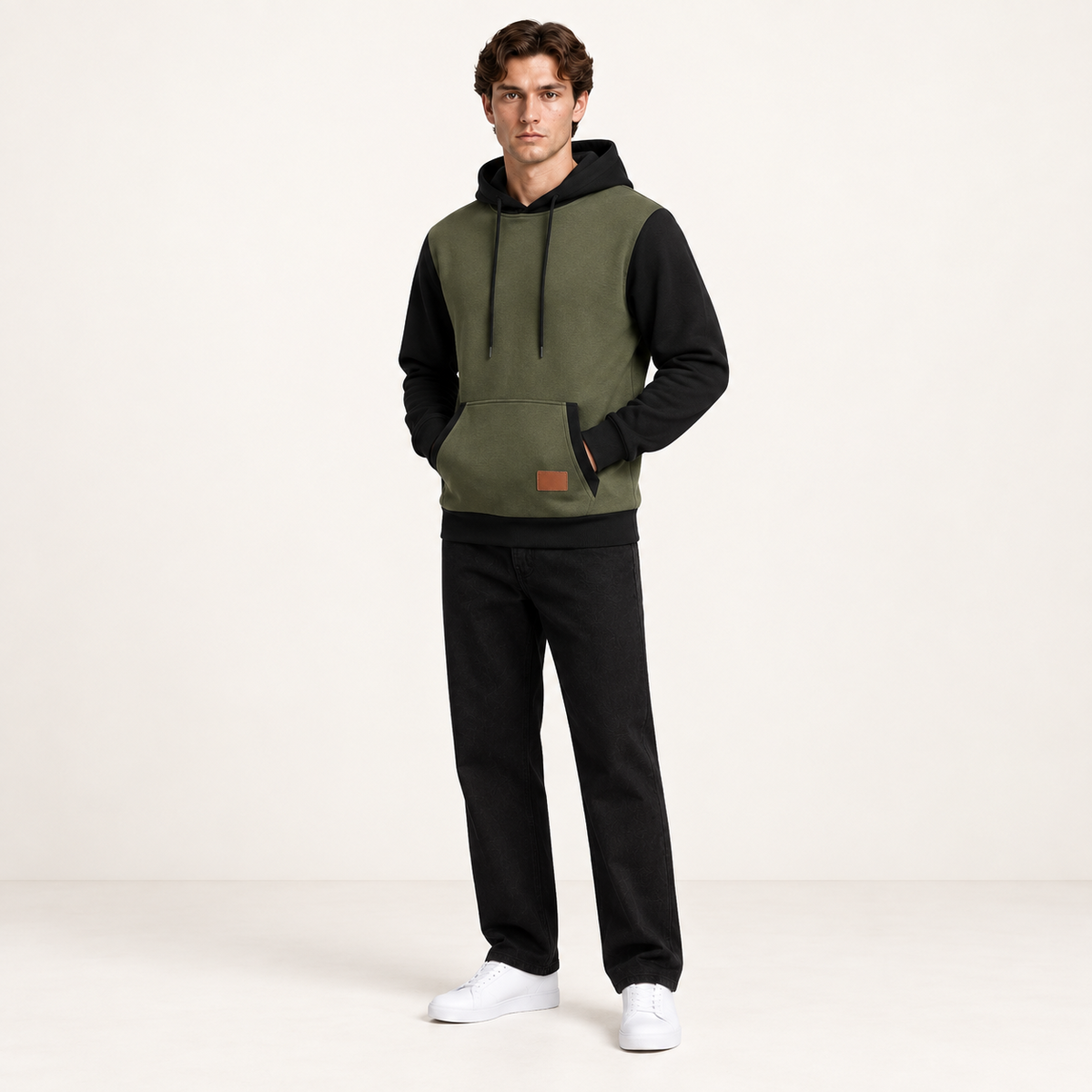 Sweat à capuche color-block vert et noir, porté de trois-quarts dans le studio IVAREE.