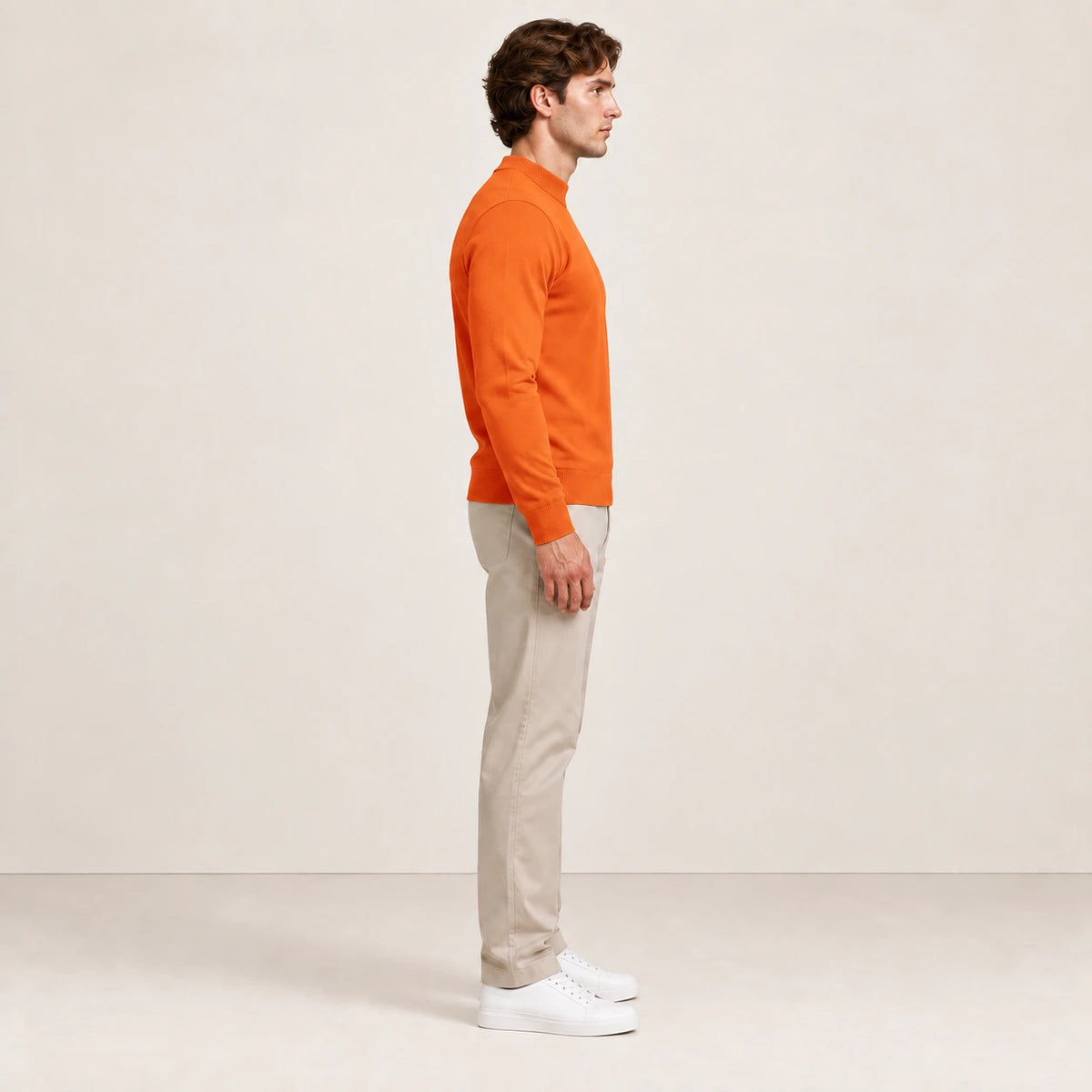 Sweat uni orange à col légèrement montant, porté de profil dans le studio IVAREE.