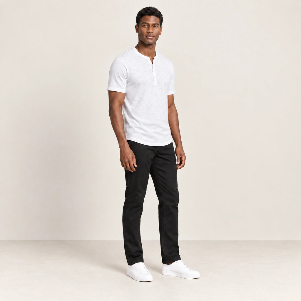 T-shirt blanc à col Henley boutonné, porté de trois-quarts dans le studio IVAREE.