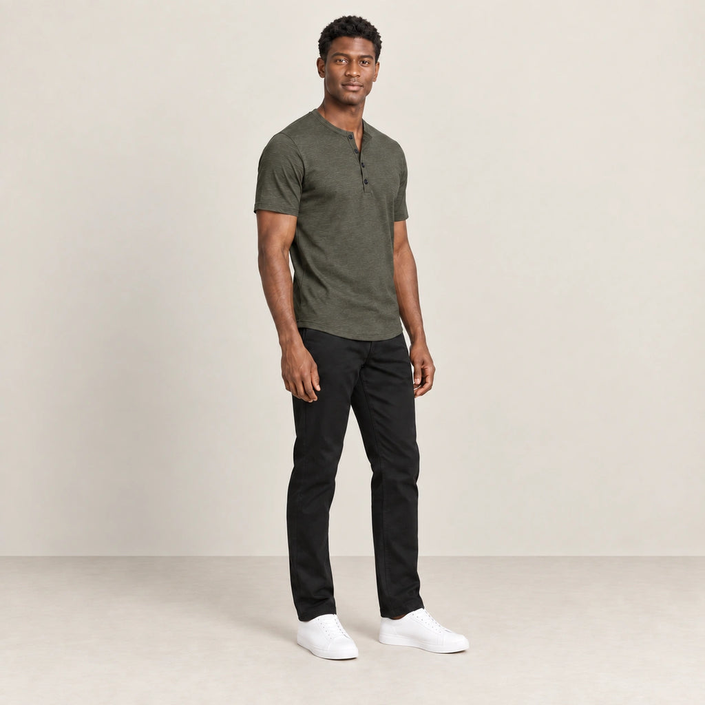 T-shirt vert militaire à col Henley boutonné, porté de trois-quarts dans le studio IVAREE.