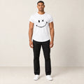 T-shirt en coton blanc à col rond et motif sourire, vue de face dans le studio IVAREE.