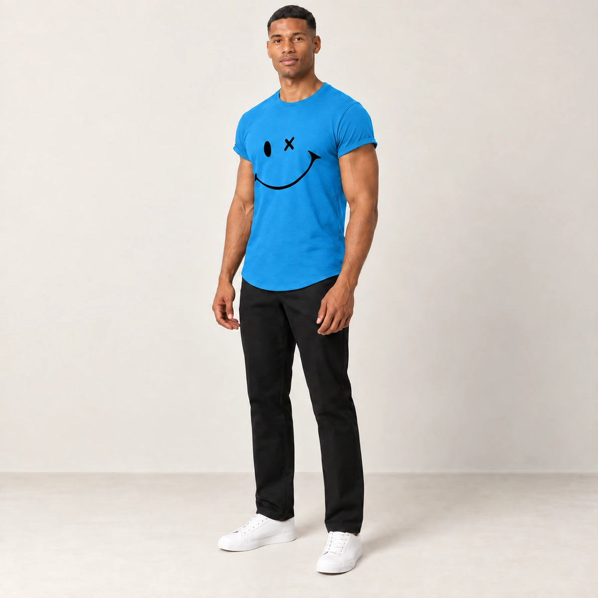 T-shirt en coton bleu à col rond et motif sourire, porté de trois-quarts dans le studio IVAREE.