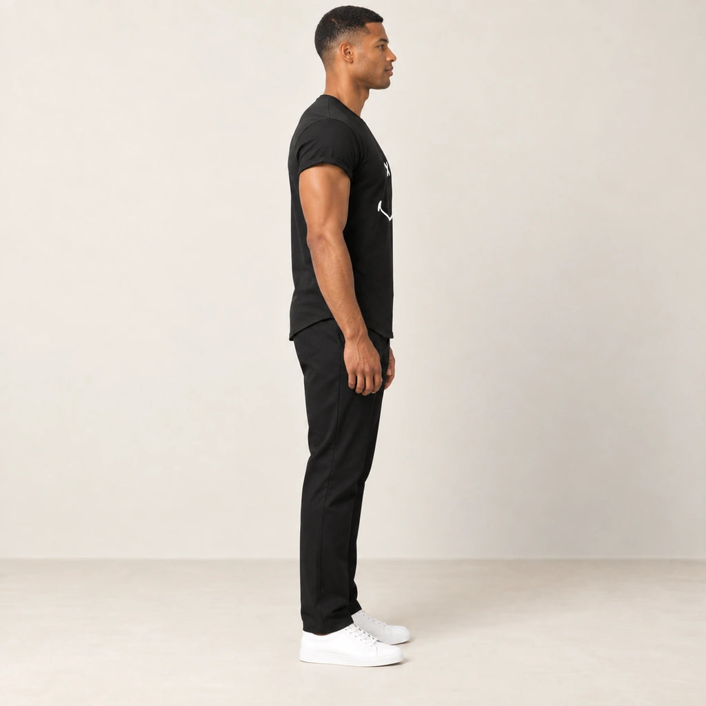 T-shirt en coton noir à col rond et motif sourire, vue de profil dans le studio IVAREE.