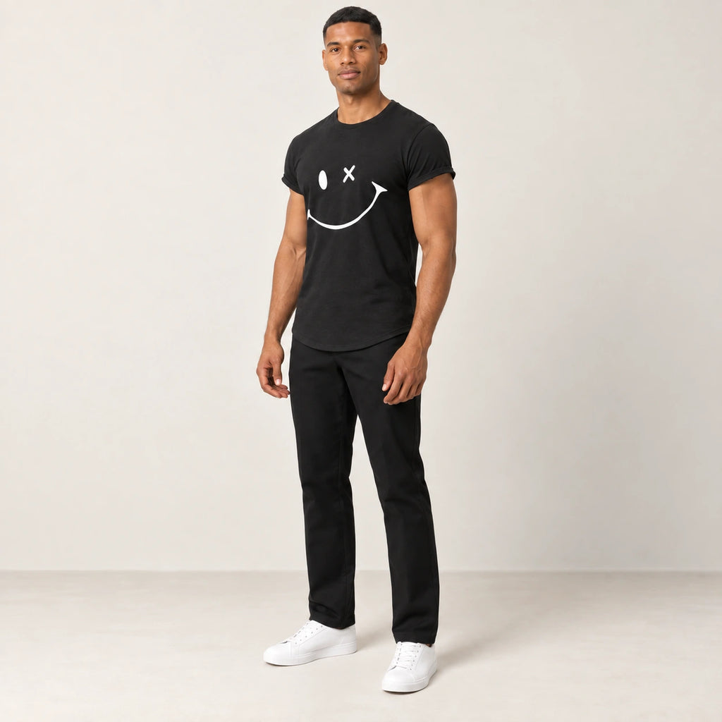 T-shirt en coton noir à col rond et motif sourire, porté de trois-quarts dans le studio IVAREE.