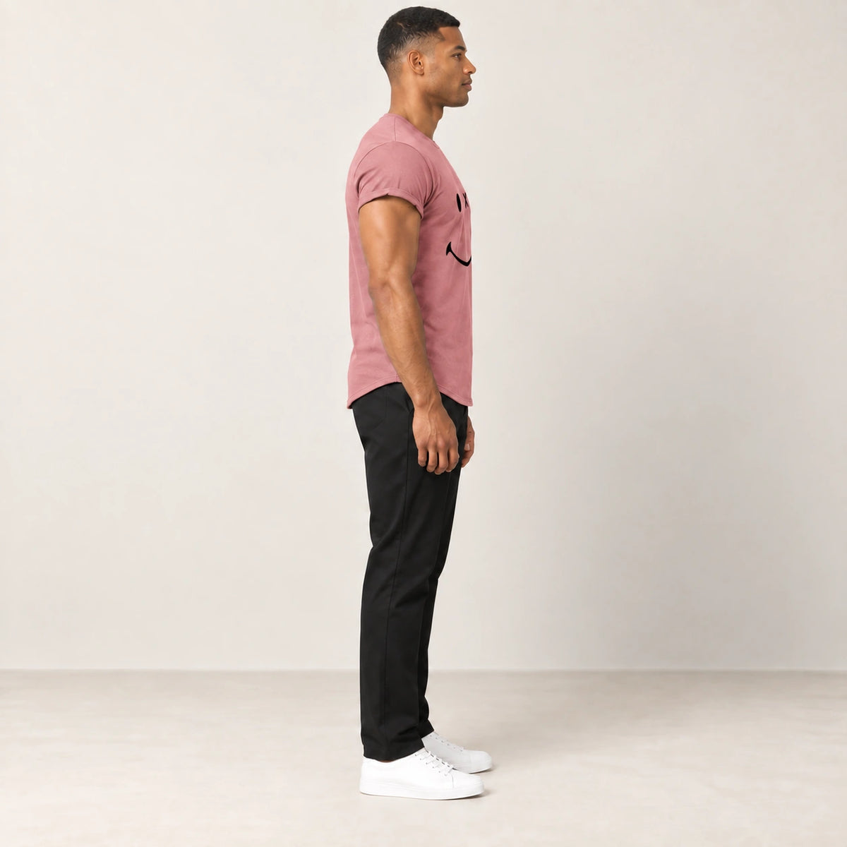 T-shirt en coton rose à col rond et motif sourire, vue de profil dans le studio IVAREE.