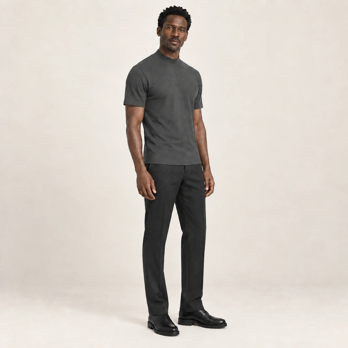 T-shirt gris anthracite à col montant et manches courtes, porté de trois-quarts dans le studio IVAREE.