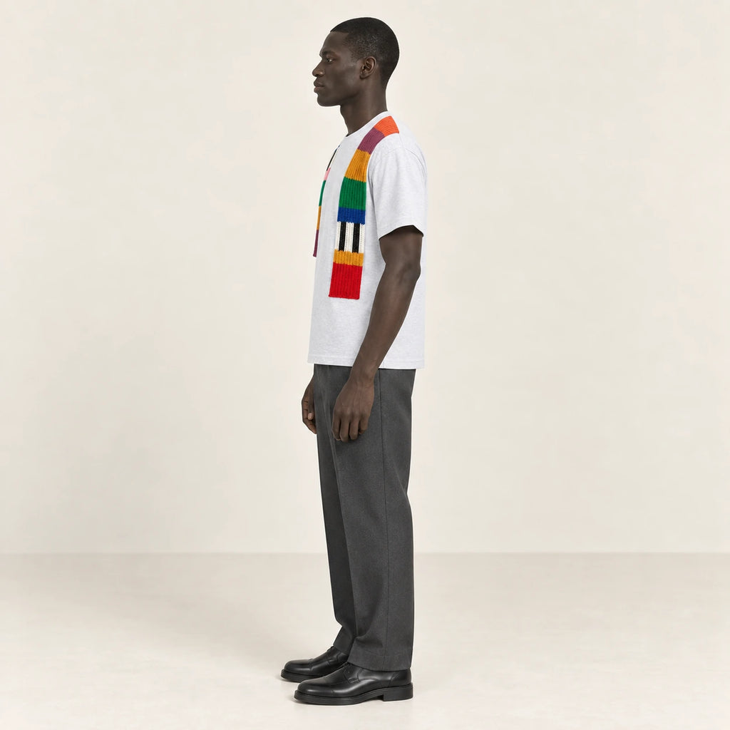 T-shirt gris clair à bandes de maille multicolores, porté de profil dans le studio IVAREE.