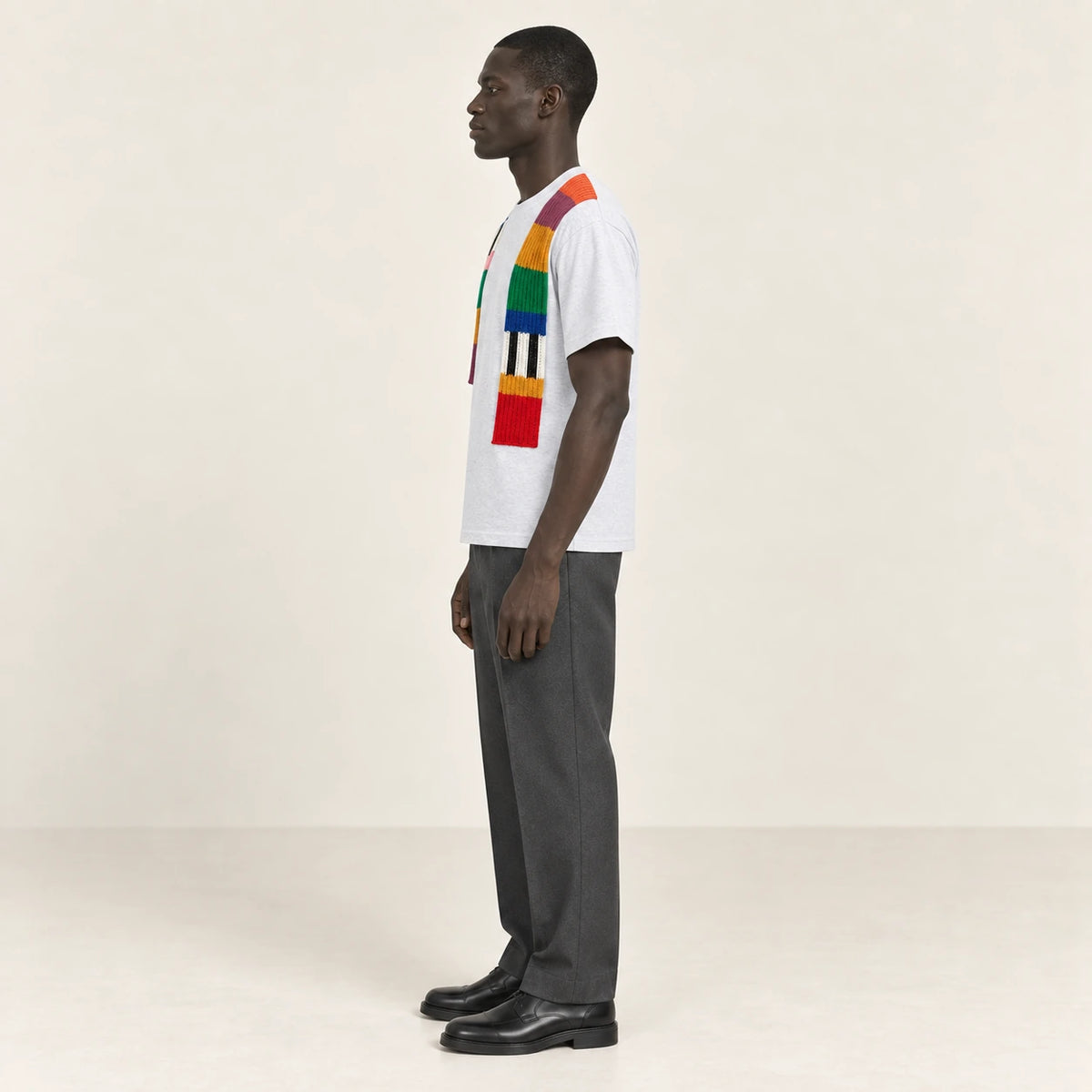T-shirt gris clair à bandes de maille multicolores, porté de profil dans le studio IVAREE.