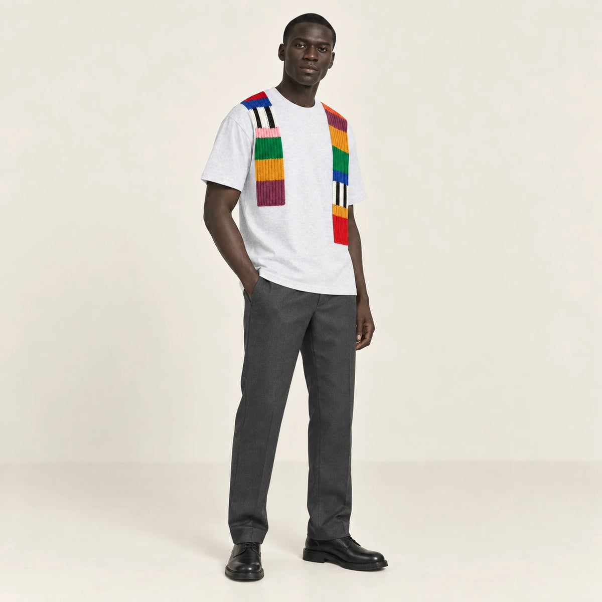 T-shirt gris clair à bandes de maille multicolores, porté de trois-quarts dans le studio IVAREE.