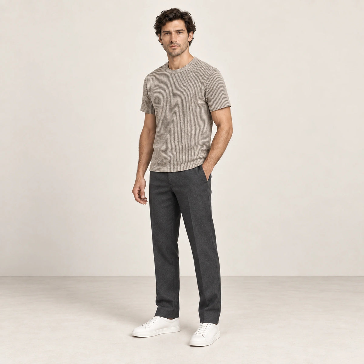 T-shirt kaki clair en maille jacquard à fines lignes verticales, porté de trois-quarts dans le studio IVAREE.