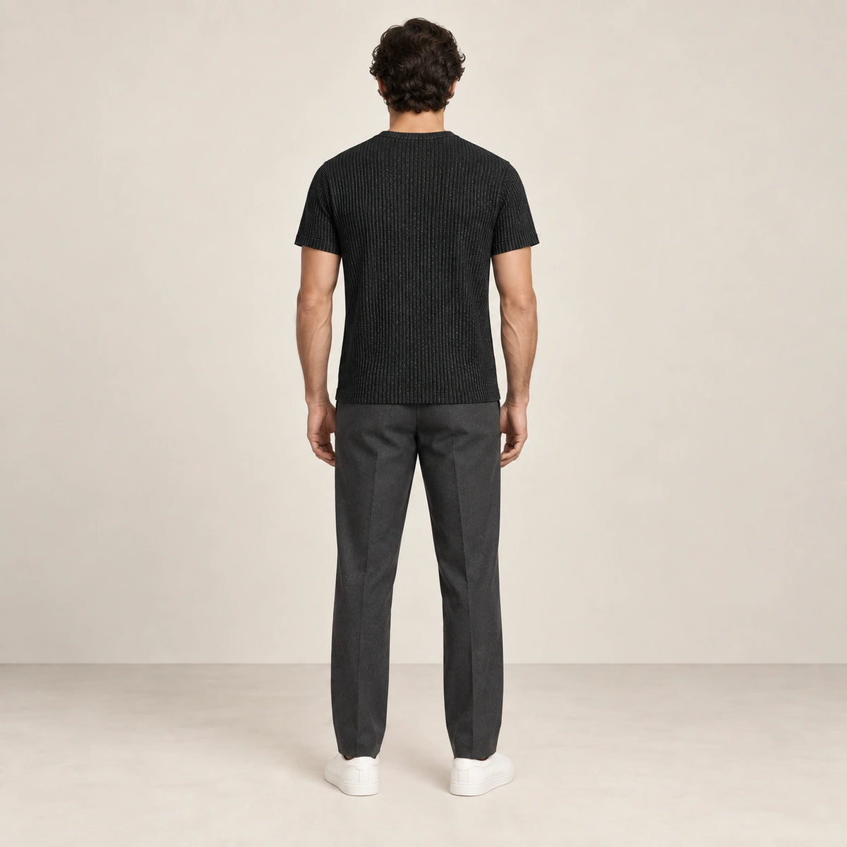 T-shirt noir en maille jacquard à fines lignes verticales, vu de dos dans le studio IVAREE.